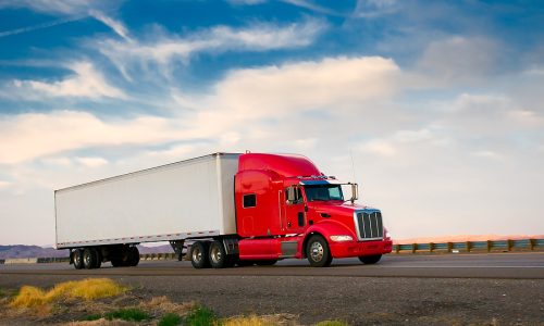 Red truck moving on a vibrant highway
